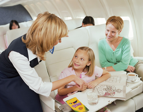 Mother and Daughter on Long Flight. Stewardess plays with child.