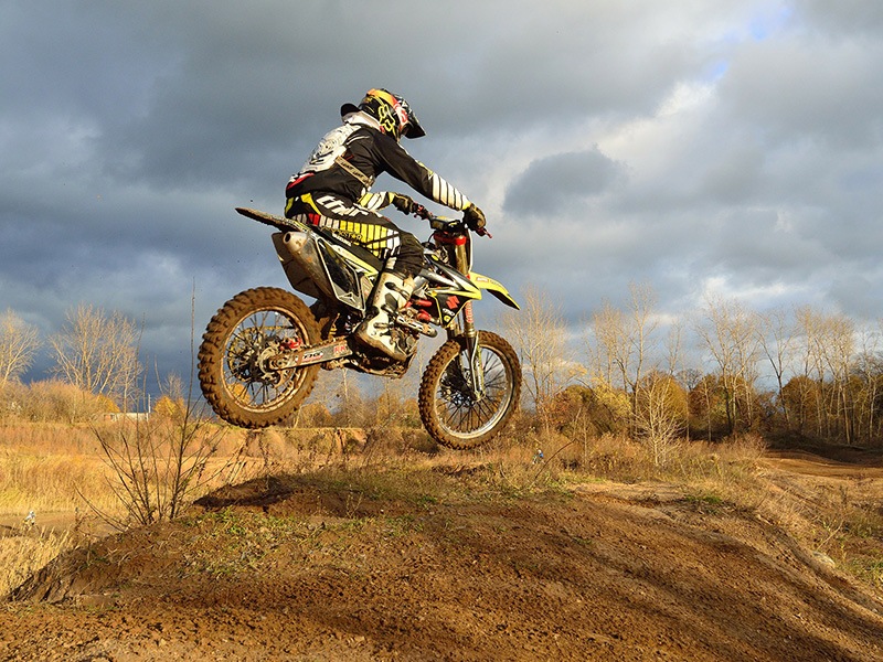 Photo of a mountain biker with adventure travel insurance jumping while on vacation