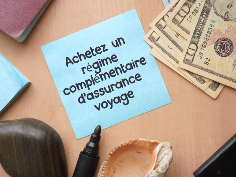 Note avec “achetez un régime complémentaire d’assurance voyage” écrite dessus.
