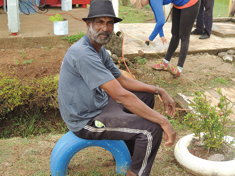 Photo of a Fijian man sitting on a tire, taken as part of a volunteer program there.