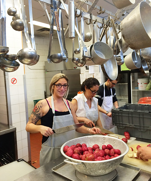 Bénévoles employés de TuGo en train de couper des pommes de terre à la Mission Old Brewery de Montréal