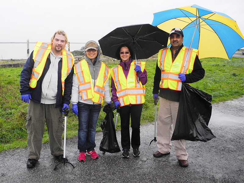 Employés de TuGo faisant du bénévolat à Garry Point Park sous la pluie