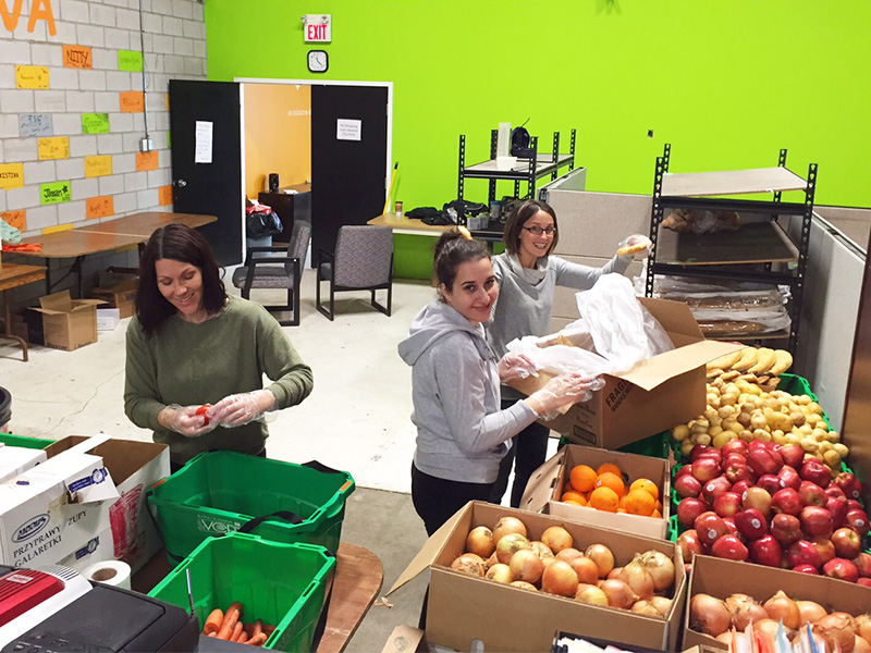 Mississauga volunteers organizing various fruits and vegetables into different containers.