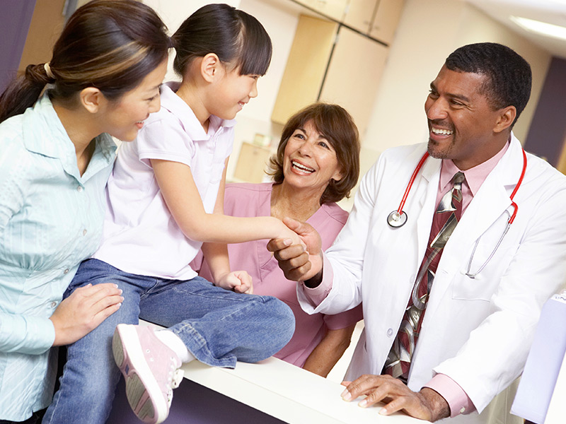 Smiling medical professionals with patient