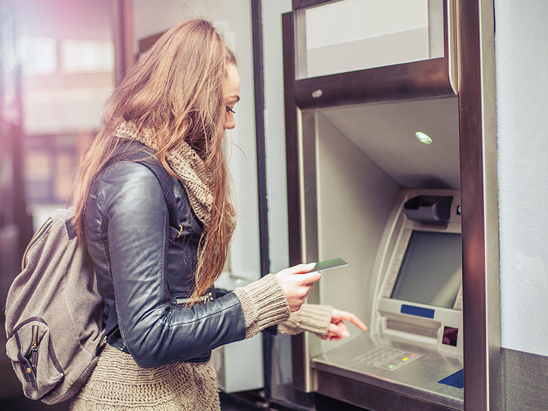 Femme effectue un retrait à un guichet automatique 