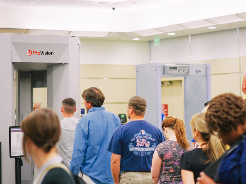 Travellers waiting in line to go through security screening at the airport.