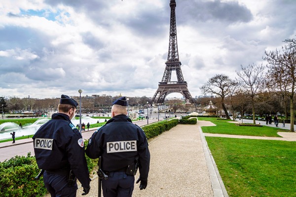 police walking together in front of Eiffel Tower