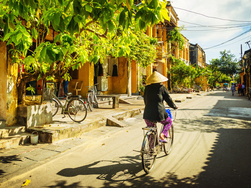 une femme en bicyclette dans les rues d’hôi an