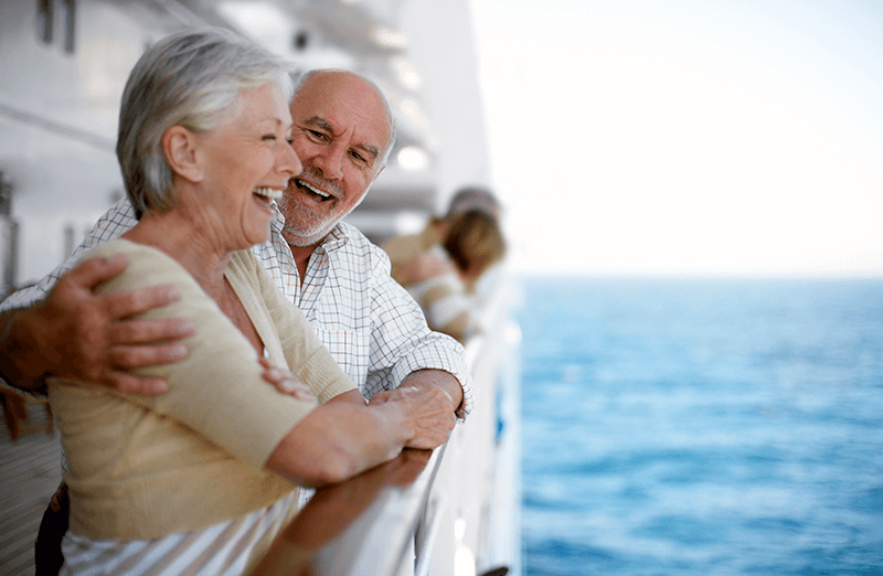 Un couple aîné regarde le paysage depuis leur navire de croisière