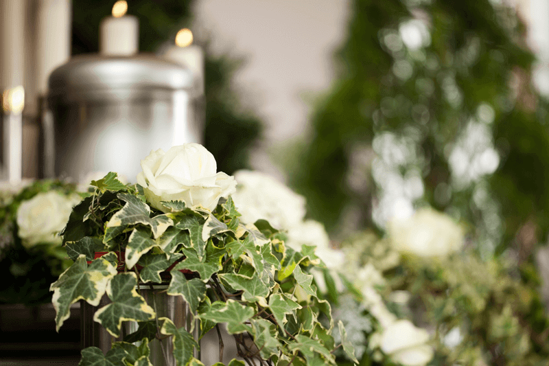 Urn with candles, ivy and white roses