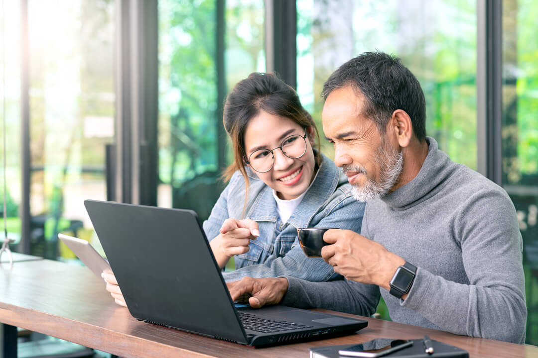 Father and daughter with laptop computer in a cafe