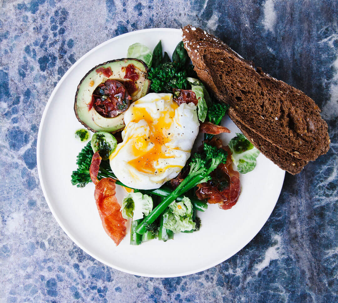 soft boiled egg, avocado and toast on a white plate