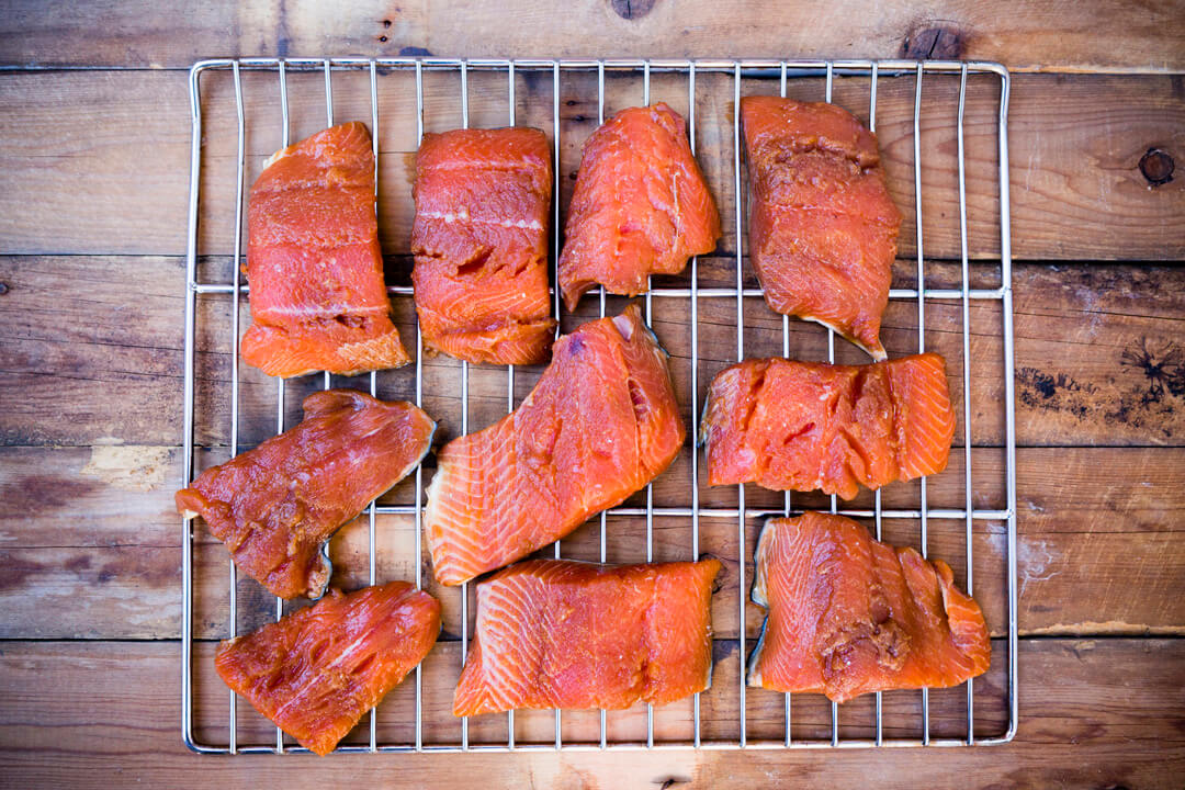 Rack of smoked salmon on rustic wooden background.