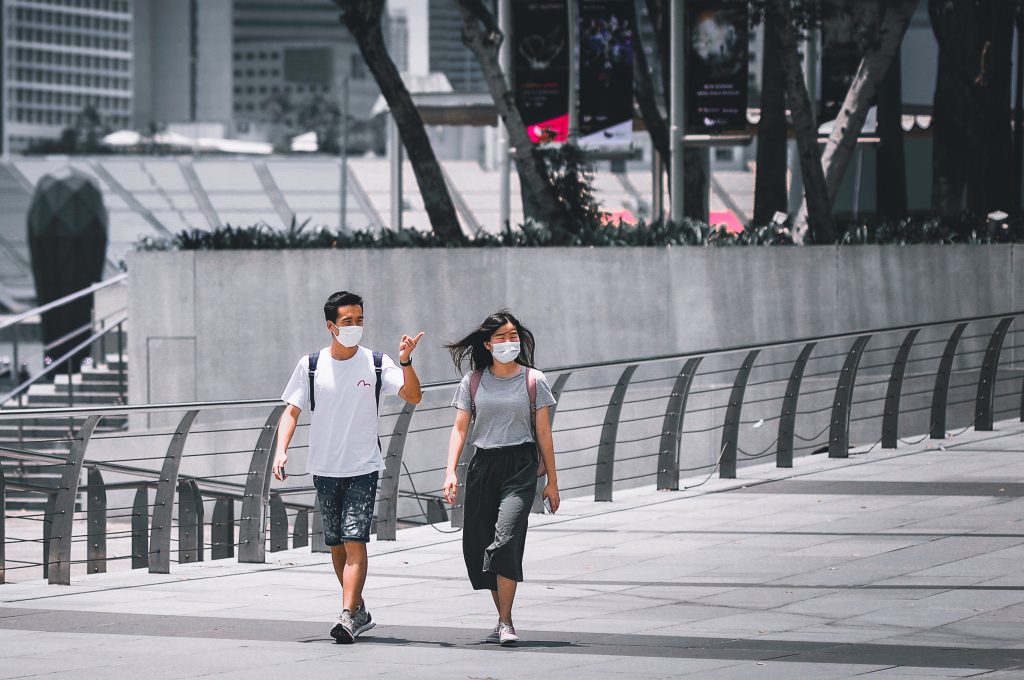 couple walks through empty city with masks on during COVID-19
