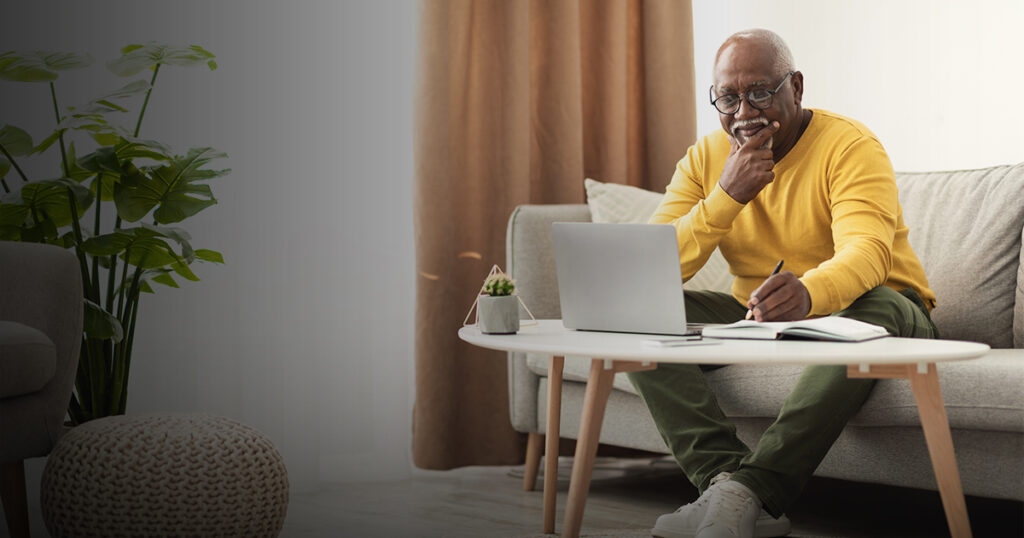 Black man sitting on computer