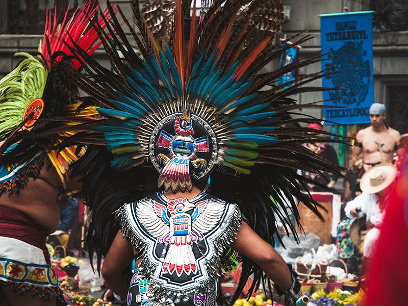 Aztec and Mesoamerican descendants gather at a square in traditional clothing